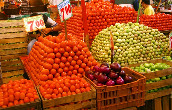 Pyramids of fresh tomatoes, indoor market,