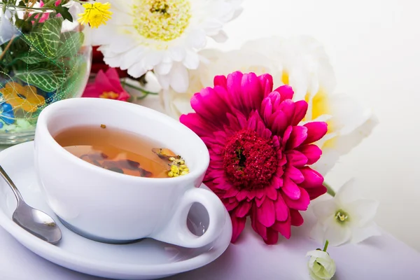 Taza de té con flor en la mesa —  Fotos de Stock