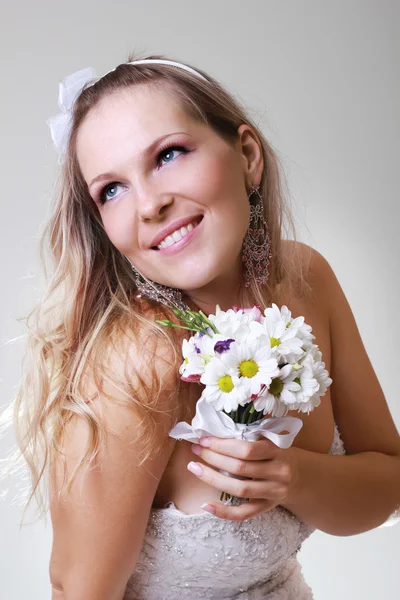 Bella giovane donna in un abito bianco con un mazzo di fiori — Foto Stock