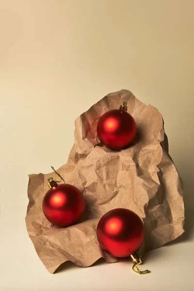 工艺纸上的圣诞装饰 米色背景下红色圣诞球的组合 带有复制空间 — 图库照片