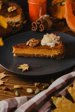 Siyah tabakta krem şanti ile süslenmiş ev yapımı balkabaklı cheesecake. Tonu. seçici odak