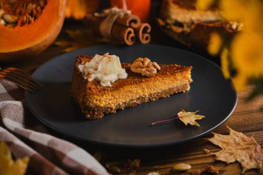 Siyah tabakta krem şanti ile süslenmiş ev yapımı balkabaklı cheesecake. Tonu. seçici odak