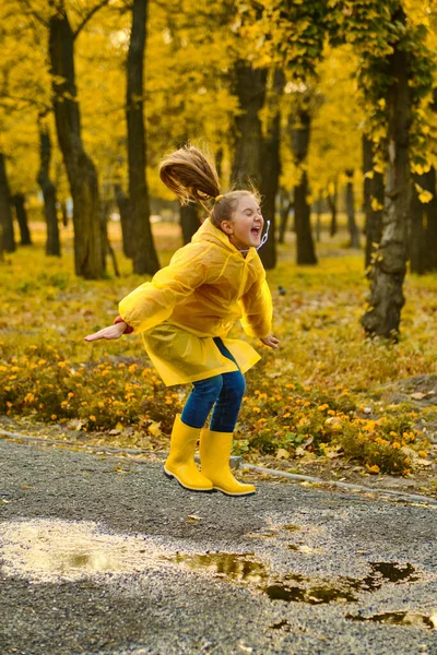 Little Girl Yellow Raincoat Yellow Boots Jumping Puddle City Park — Stock Photo, Image