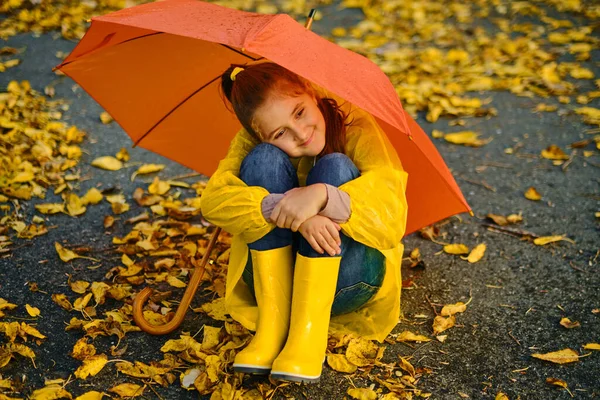 Little Girl Sitting Asphalt Orange Umbrella Rain Autumn Outdoor Fun — Stock Photo, Image