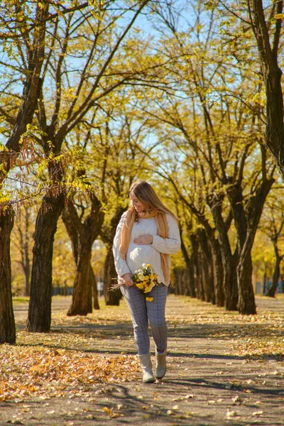 Atractiva Mujer Embarazada Milenaria Con Flores Sosteniendo Barriga Parque Otoño — Foto de Stock