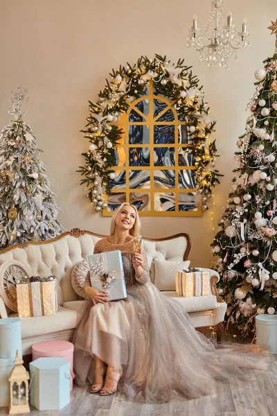 Elegantní Krásná Blond Žena Sklenkou Šampaňského Sedí Blízkosti Zdobeného Stromu — Stock fotografie