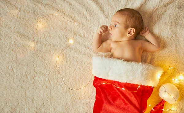 Little Newborn Baby Big Red Santa Hat Blanket Lights Garland — Stock Photo, Image