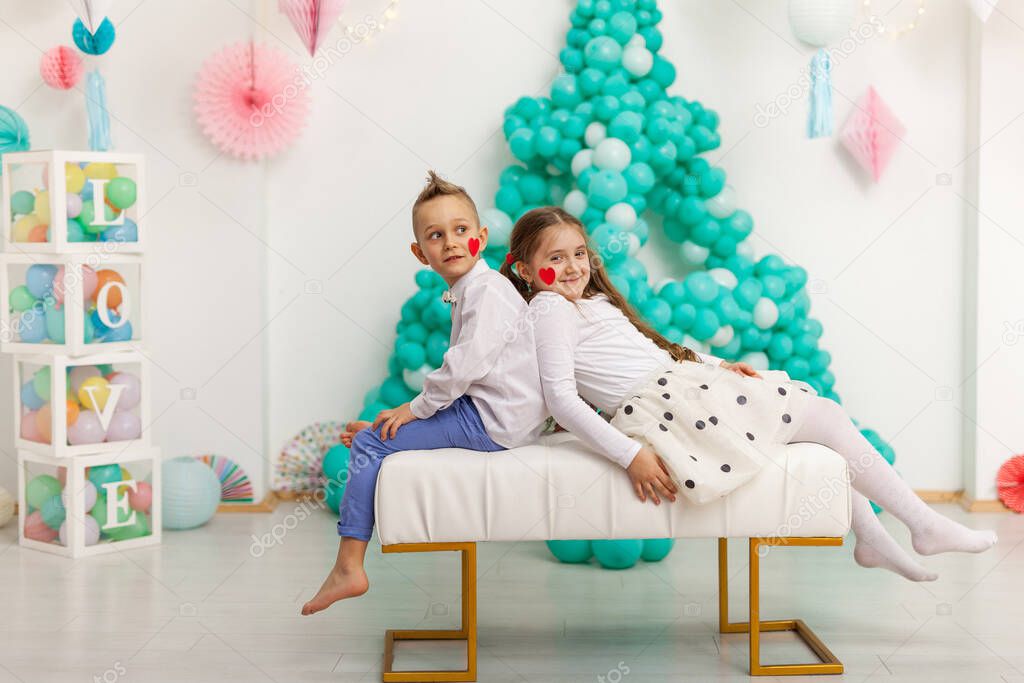 Cute couple of kids with red heart balloon. Valentine's Day and love concept, studio shot