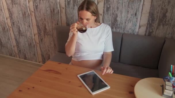 迷人的孕妇喝着长颈鹿 看着电脑屏幕上的平板电脑 怀孕和技术 网上购物概念 — 图库视频影像