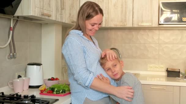 怀孕的妈妈和孩子一起玩耍在厨房里拥抱儿子听妈妈怀孕的肚子 — 图库视频影像