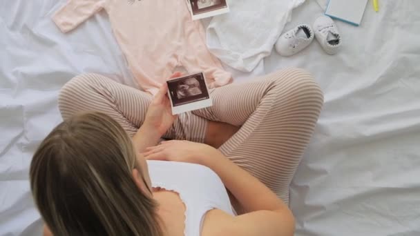 Ovanifrån Gravid Kvinna Sängen Förbereda Baby Kläder Hemma Och Titta Videoklipp