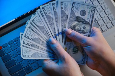 Kadın elleri para yelpazesini tutuyor 100 dolarlık banknotlar