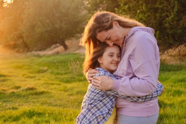 Neşeli bir anne ve kızın birbirine sarılmasına, baharda yeşil çimlerin üzerinde oynamalarına, mutlu bir aile yaşamına bakıyorum.