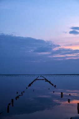 Renkli gökyüzü ve göldeki renkli su günbatımına yansıyor. Ukrayna 'da tuz gölü, güzel gün batımı