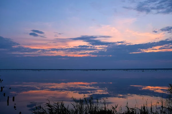 Renkli gökyüzü ve göldeki renkli su günbatımına yansıyor. Ukrayna 'da tuz gölü, güzel gün batımı