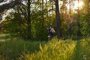 Babam, yaz ormanlarında yürüyüşe çıkan küçük kızını sırtında taşıyor..