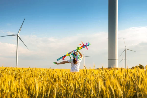 Happy Little girl running in a wheat field with a kite in the summer. Well-planned and active weekend. Happy childhood.