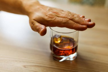 Eller içkiyi bırakmak için bir bardak viskiyi zincirliyor. Alkolizm konsepti. Alkol bağımlılığını durdur. Alkollü içeceğe bağımlı olmak.