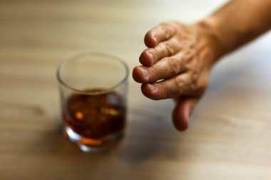 Eller içkiyi bırakmak için bir bardak viskiyi zincirliyor. Alkolizm konsepti. Alkol bağımlılığını durdur. Alkollü içeceğe bağımlı olmak.