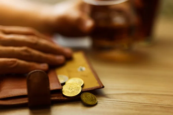 자기의 마지막 돈으로 알코올 마시라고 알코올 중독자는 탁자에 얼음이 동전이 — 스톡 사진