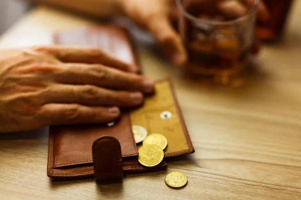 자기의 마지막 돈으로 알코올 마시라고 알코올 중독자는 탁자에 얼음이 동전이 — 스톡 사진