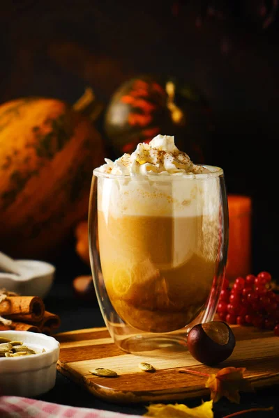 Pumpkin latte with whipped cream in a glasses in the style of dark food. Autumn Hot spicy drink for Halloween or Thanksgiving. selective focus