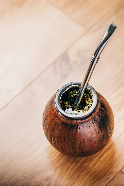 South American traditional mate drink in calabash on a wooden floor