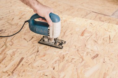 Katılımcının işi, iç dekorasyon için elektrikli yapbozlu kontrplak kullanmaktır.