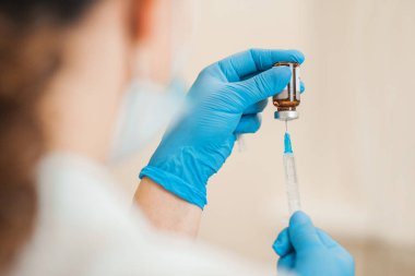 Coronavirus enfeksiyonu COVID-19 - Doktor Coronavirus aşısı ortaya çıktığında şırıngaya aşı enjekte ediyor.