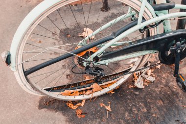 Terk edilmiş, arka tekeri kırık ve tekerleği olmayan bir bisiklet.