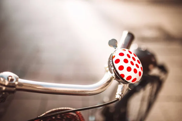 シルバーメタル自転車ハンドルバーで素敵な赤い点のかわいい白い自転車の鐘 コピースペースとぼやけた背景 安全性 — ストック写真