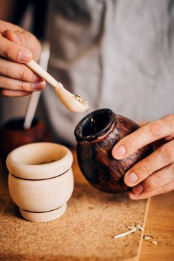 İnsan ahşap kaşıkla bitki çayı doldurur - doğal kuru otlar.