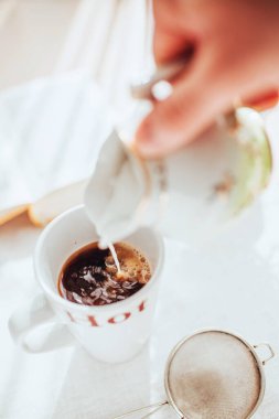 Bir fincan kahvenin içinde ince bir akarsu ılık süt - sütlü sabah kahvesi - tatlı aromatik sıcak içecek