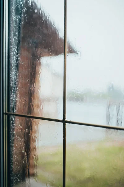 Raindrops on the wet glass of the window - rain and hurricane outside the window