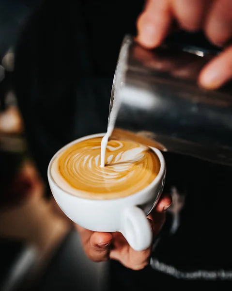 专业的咖啡师把白牛奶拿铁泡沫倒入一杯咖啡 这是酿造优质卡布奇诺的艺术 — 图库照片