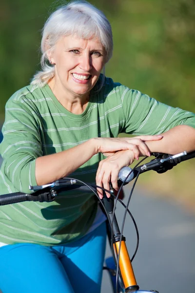 Mature woman with bicycle — Stock Photo, Image