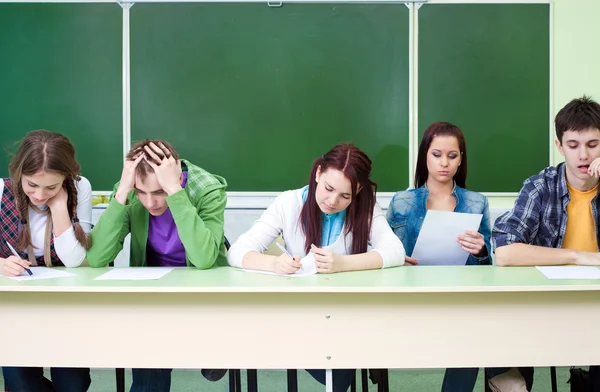 Estudantes em exame em classe — Fotografia de Stock