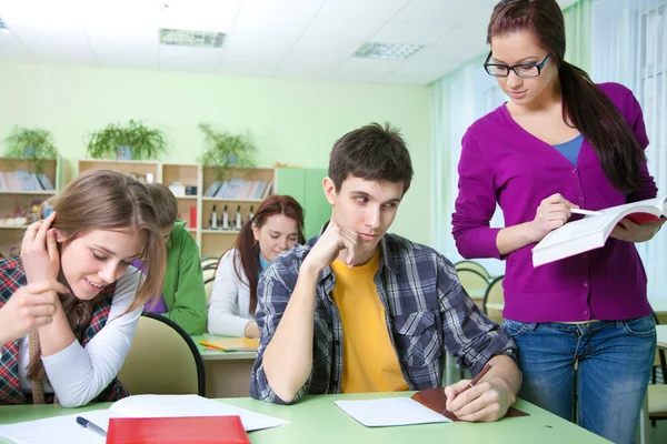 Teacher with group of students in classroom Stock Photo