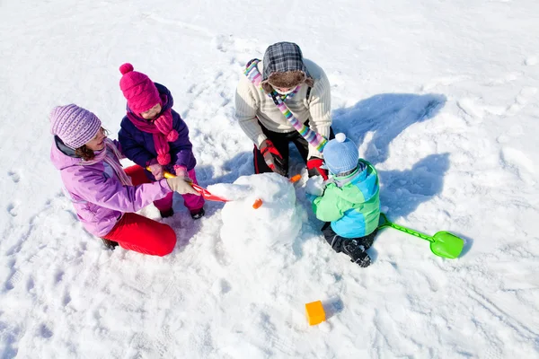 Família feliz fazendo boneco de neve — Fotografia de Stock