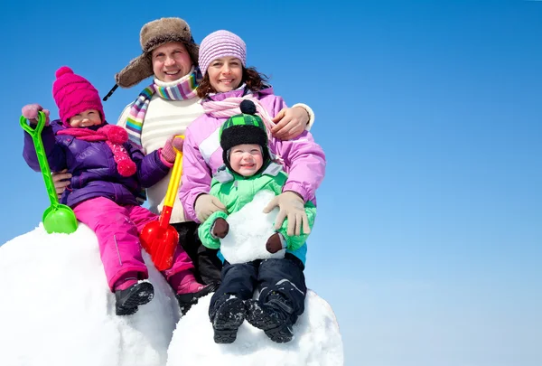 Gelukkige familie sneeuwpop maken — Stockfoto