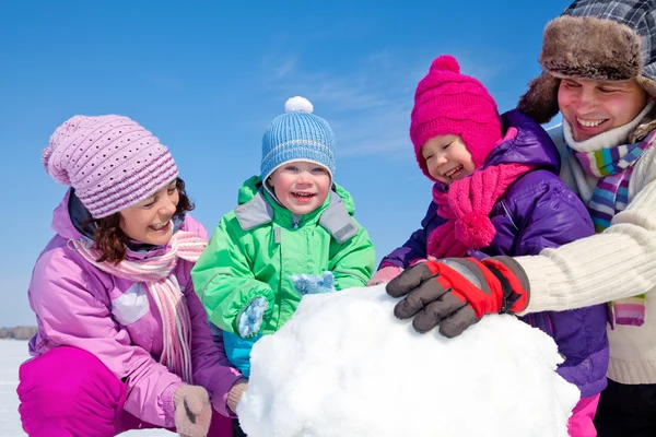 Ευτυχισμένη οικογένεια κάνοντας χιονάνθρωπος — Φωτογραφία Αρχείου