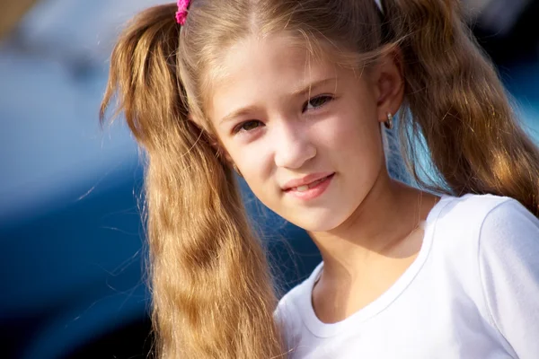 Porträtt av liten flicka med långt hår, ler mot kameran — Stockfoto