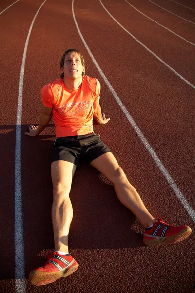 Atleta se sienta en el estadio de la cinta de correr —  Fotos de Stock