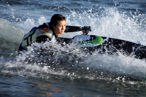 Mooi meisje paardrijden haar jet ski 's — Stockfoto