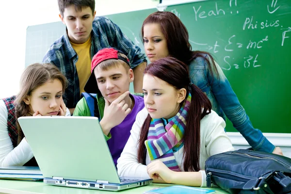 Grupo de jóvenes estudiantes que estudian en el aula con una computadora portátil — Foto de Stock