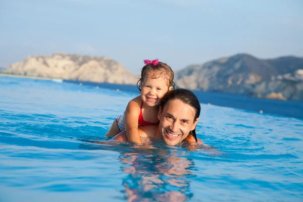 Père avec sa fille nageant dans la piscine — Photo