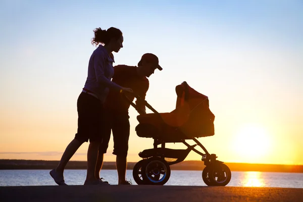 Ευτυχισμένη οικογένεια περπάτημα στο ηλιοβασίλεμα — Φωτογραφία Αρχείου