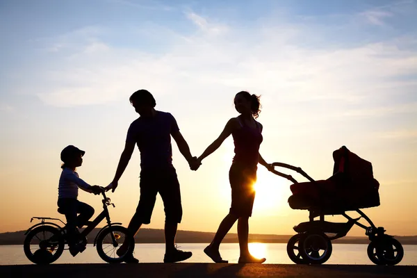 Familia feliz caminando al atardecer Imágenes de stock libres de derechos