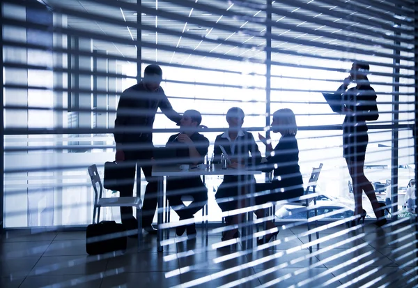 Silhouetten van mensen uit het bedrijfsleven via de blinds — Stockfoto