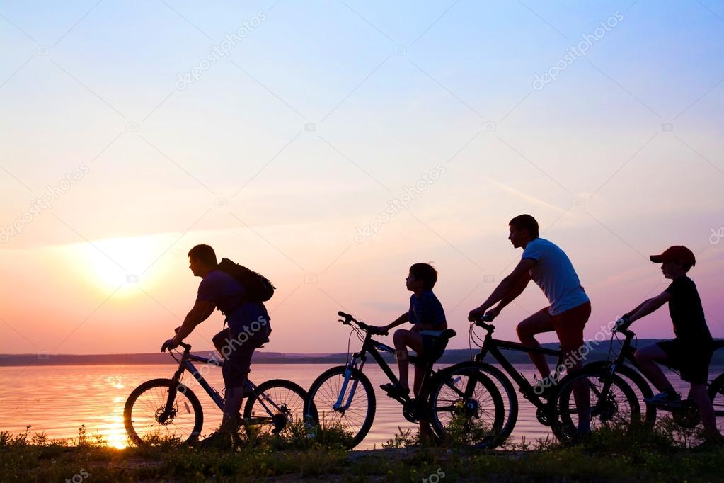 Family on bicycles admiring the sunset